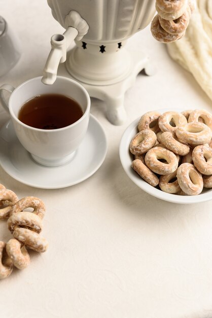 Un samovar con bagel e tè caldo sulla tovaglia bianca