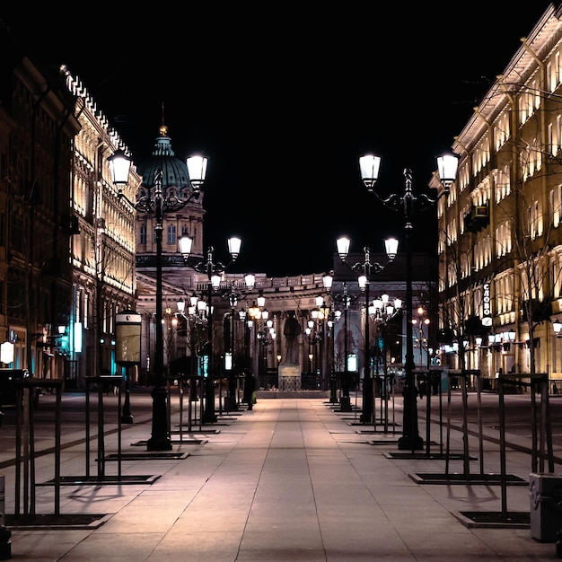 Un sentiero vuoto illuminato da lampioni in mezzo agli edifici