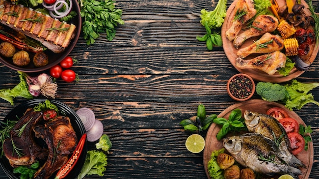 Un set di cibo Bistecca Pesce Verdure e spezie su uno sfondo di legno Vista dall'alto Copia spazio