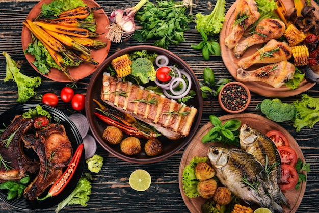 Un set di cibo Bistecca Pesce Verdure e spezie su uno sfondo di legno Vista dall'alto Copia spazio