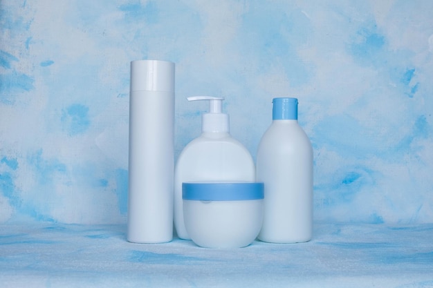 Un set di contenitori in plastica bianca Modello di bottiglia di imballaggio per cosmetici antisettici con detergenti e detergenti chimici per prodotti medici e cosmetici Sfondo blu bianco