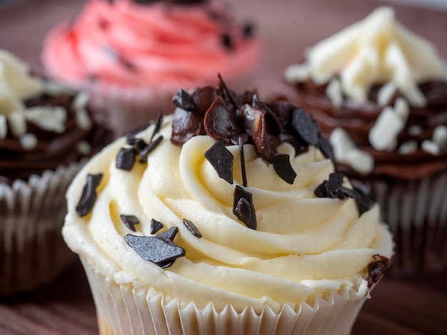 Un set di deliziosi e dolci cupcakes al cioccolato su uno sfondo di legno. Dessert ipercalorico, messa a fuoco selettiva