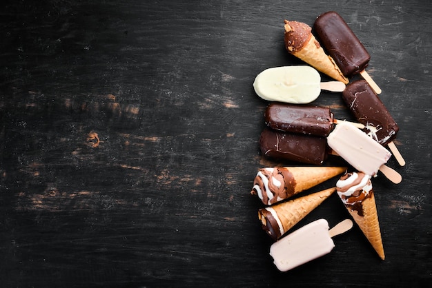 Un set di gelato con noci di cioccolato e marmellata su sfondo nero Vista dall'alto Spazio libero per la copia