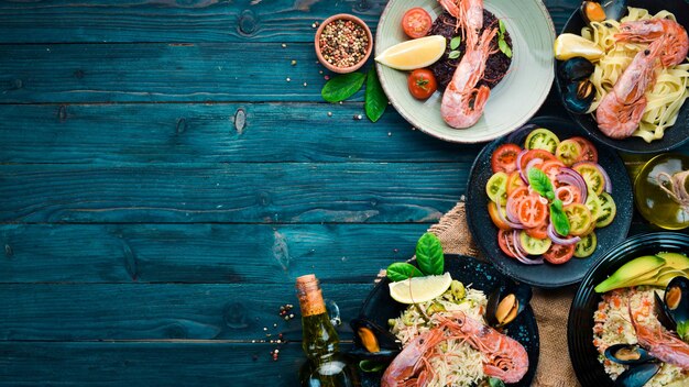 Un set di piatti a base di pesce su sfondo blu in legno Pasta bulgur riso cuscus Vista dall'alto Spazio libero per il testo