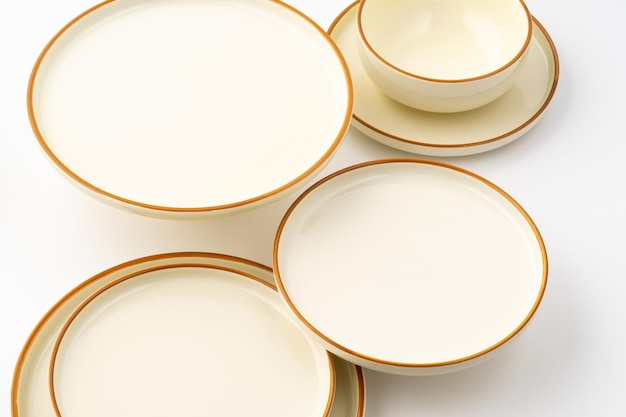 Un set di piatti e ciotole in ceramica bianca e marrone su sfondo bianco