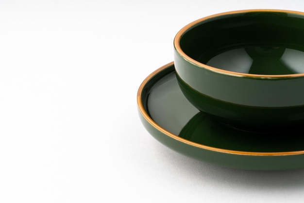 Un set di piatto in ceramica verde e tazza da caffè su sfondo bianco