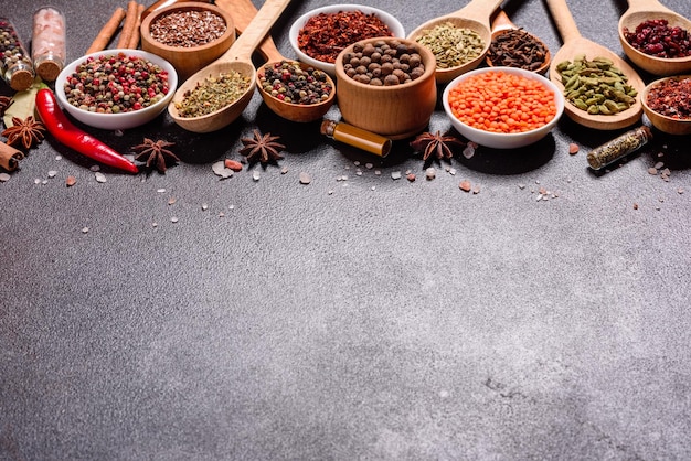 Un set di spezie ed erbe cucina indiana pepe sale paprika basilico e altri su uno sfondo scuro
