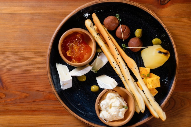 Un set di stuzzichini con crostini di pane, marmellata, cioccolato, formaggio e olive