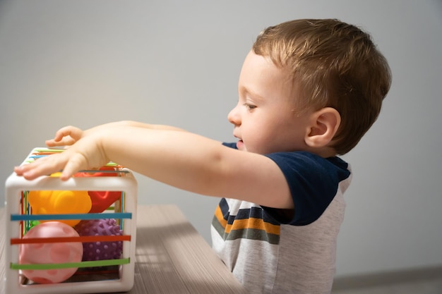 Un simpatico bambino gioca con palline colorate sensoriali Attività sensoriali e tattili Giochi per bambini di un anno e mezzo Bambino attento Messa a fuoco selettiva