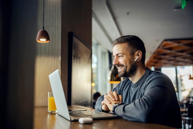 Un simpatico libero professionista è seduto in un bar e fa una teleconferenza con un cliente