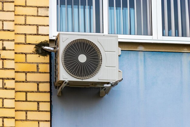 Un sistema di condizionamento installato all'esterno sulla parete di un edificio in muratura. Ventilazione e condizionamento dell'abitazione