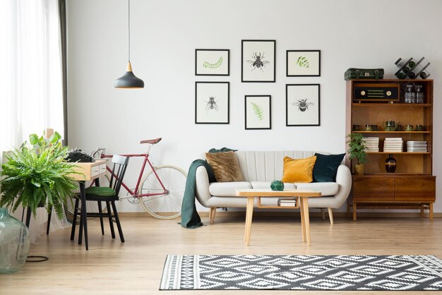 Un soggiorno con un divano, un tavolo e una bici appesa al muro.