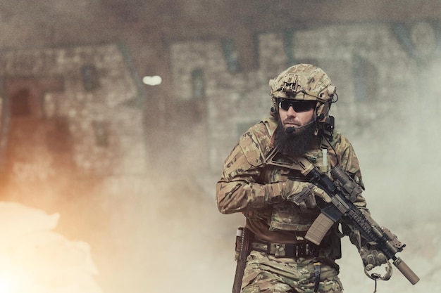 Un soldato barbuto in uniforme delle forze speciali in una pericolosa azione militare in un'area nemica pericolosa Focalizzazione selettiva