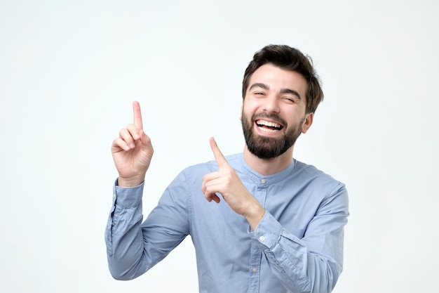 Un sorridente con la faccia felice che guarda e indica il lato con il dito