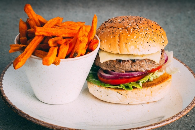 Un succulento hamburger gourmet con contorno di patate dolci fritte