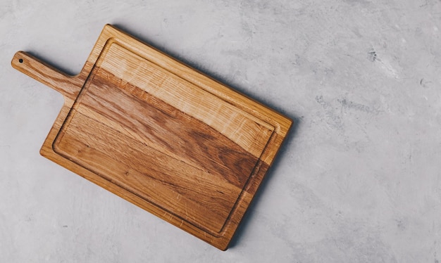 Un tagliere di legno su sfondo di pietra di cemento grigio Vista dall'alto con spazio per la copia