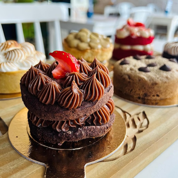 Un tavolo con diverse torte e una con sopra una fragola.