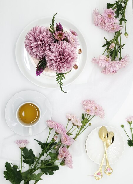 Un tavolo con sopra un piatto di fiori e una tazza di tè