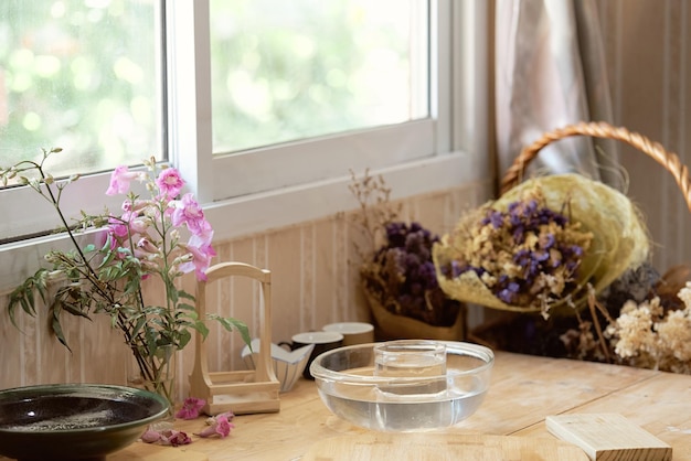 Un tavolo con un cesto di fiori e una pianta