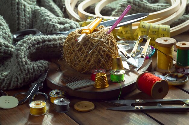 Un tavolo con una varietà di materiali per cucire tra cui una macchina da cucire, un ago, un ago, un ago e altri materiali per cucire.