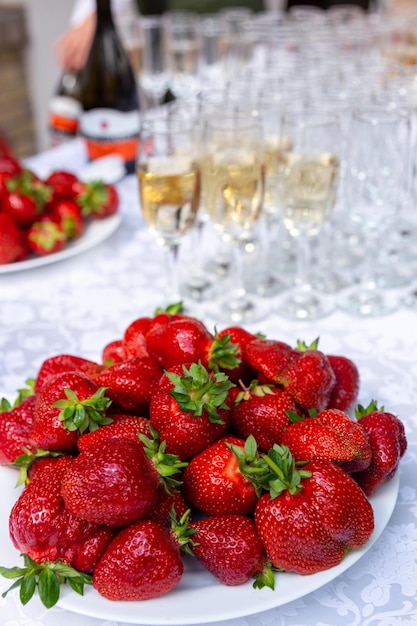 Un tavolo da banchetto con bicchieri da vino e piatti con fragole