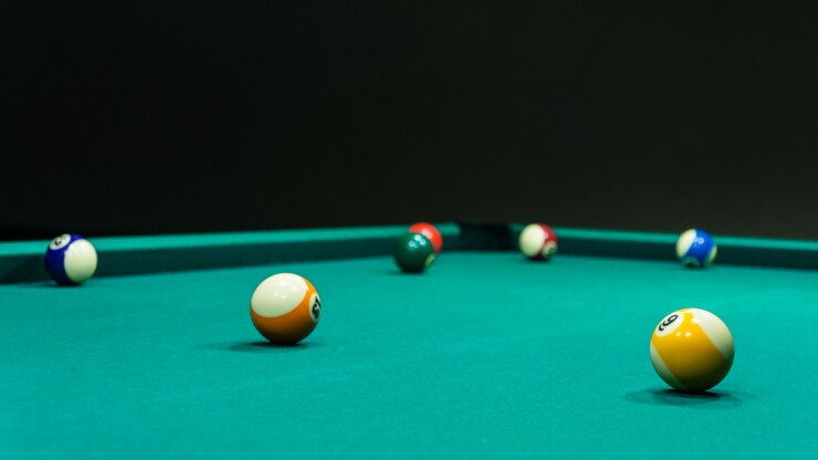 Un tavolo da biliardo vuoto con palline rotolanti