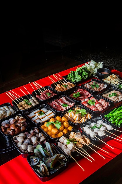 Un tavolo da buffet con vari cibi tra cui carne, verdure e carne.