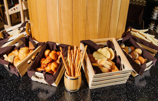 Un tavolo da buffet con varietà di pane nei cesti di legno