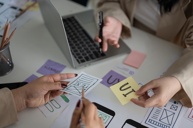 Un tavolo di incontro con un team di grafici creativi UI UX che lavorano su un prototipo di app mobile