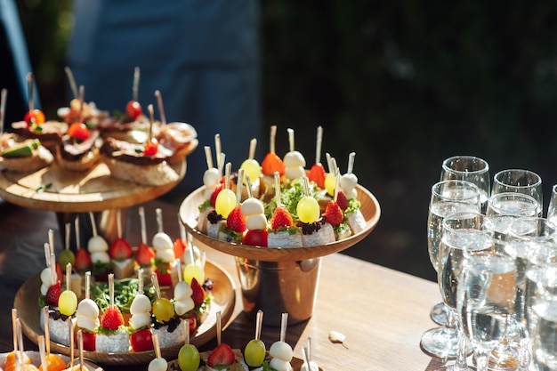 Un tavolo di vari snack, tramezzini, fragole e altri tipi di snack