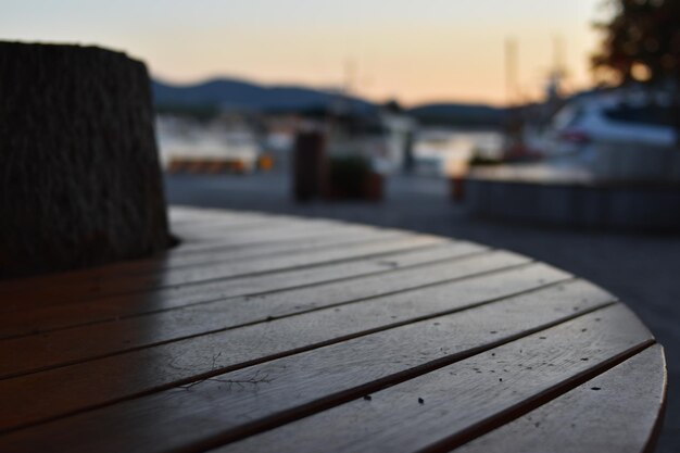 Un tavolo in legno con vista sul porto al tramonto.