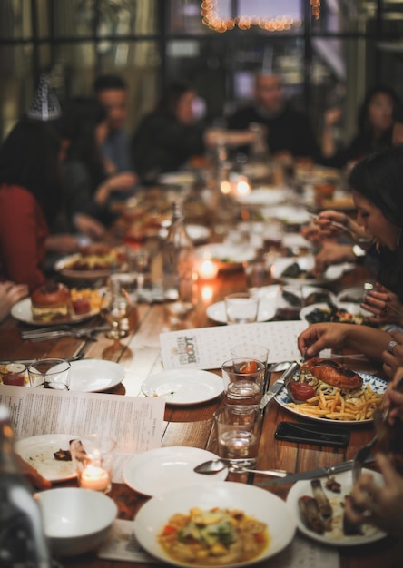 Un tavolo pieno di persone che mangiano in un ristorante.