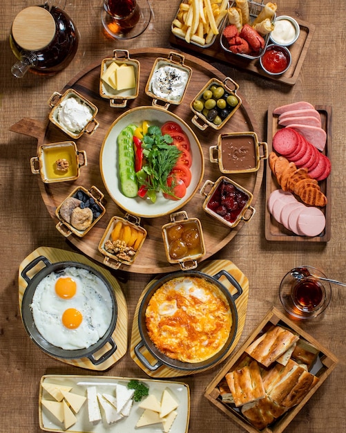 Un tavolo pieno di prodotti per la colazione tra cui uova, formaggio e pane.