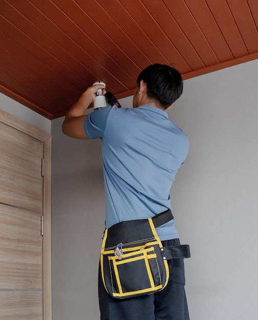 Un tecnico installa una telecamera CCTV in un appartamento moderno