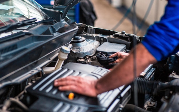 Un tecnico sta ispezionando il motore dell'auto per trovare il problema