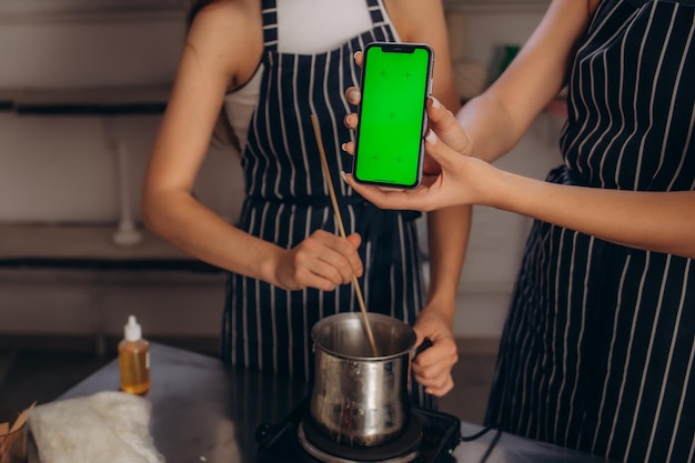 Un telefono con uno schermo verde sullo sfondo di una candela