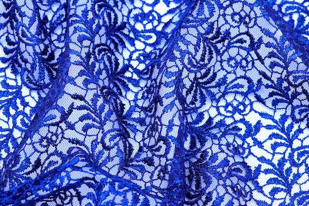 Un tessuto di pizzo blu con un motivo di fiori.
