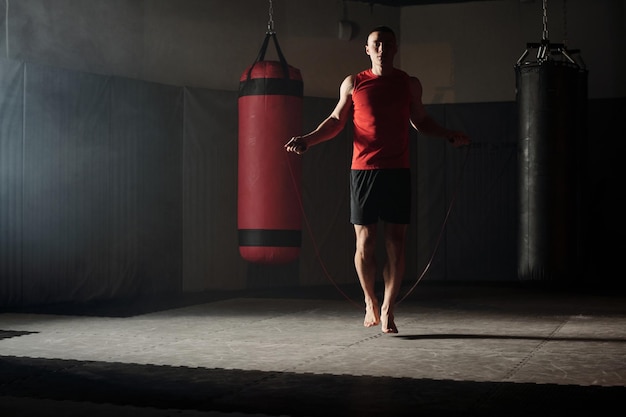 Un tizio che salta con la corda da salto in palestra.