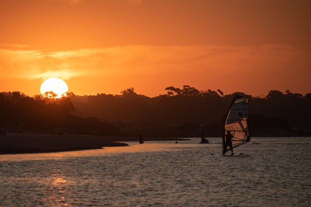 Un tramonto con una barca a vela in acqua