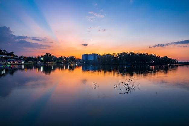 Un tramonto su un lago con un edificio sullo sfondo