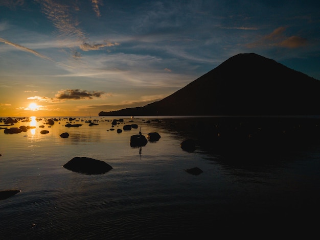 Un tramonto su una montagna con una montagna sullo sfondo Banda Island Maluku