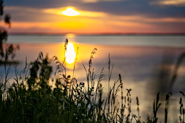 Un tramonto sull'acqua con il sole che tramonta dietro di esso