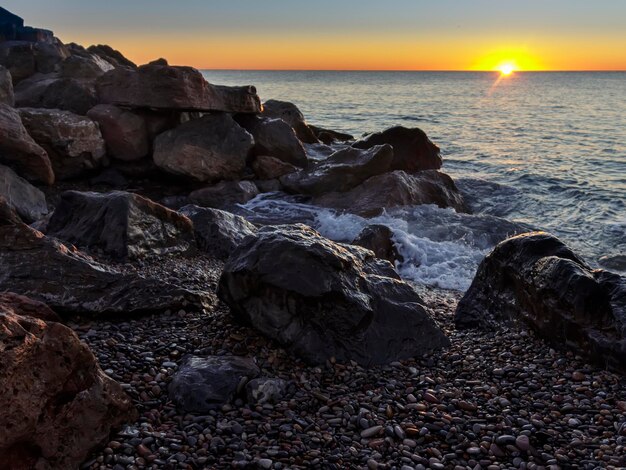 Un tramonto sull'oceano con il sole che tramonta dietro di esso