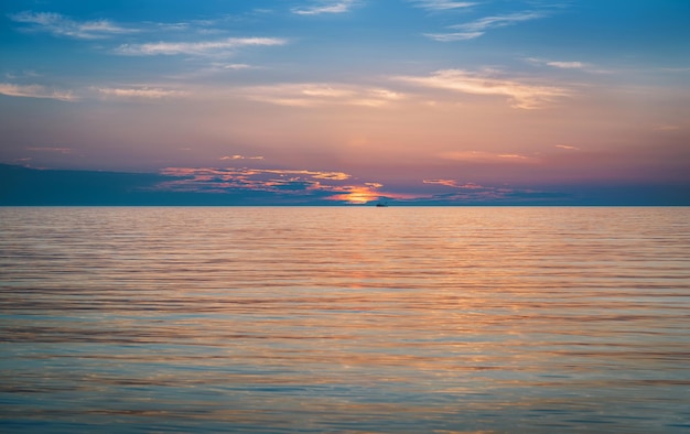 Un tramonto sull'oceano con un cielo blu e nuvole