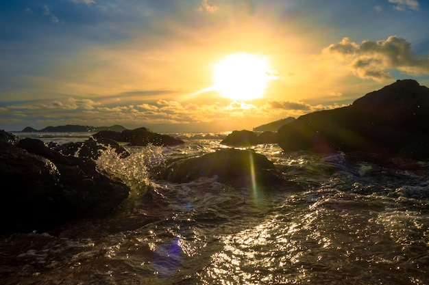 Un tramonto sulla spiaggia con il sole che tramonta alle sue spalle