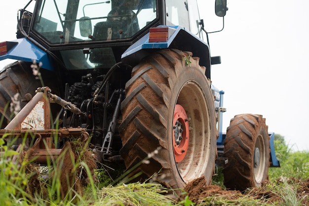 Un trattore blu che lavora su terreni agricoli