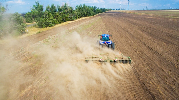 Un trattore che ara e che semina nel campo