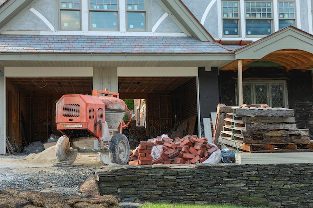 Un trattore rosso è fuori da una casa che è stata spalata di legno.