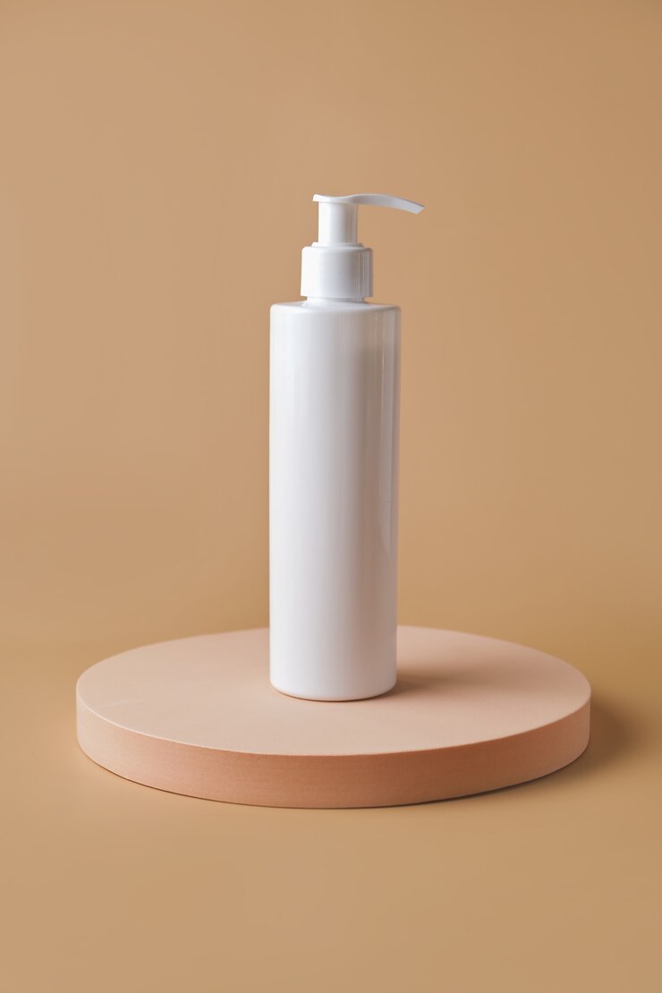 Un tubo per cosmetici con crema su piedistallo sulla superficie verticale beige