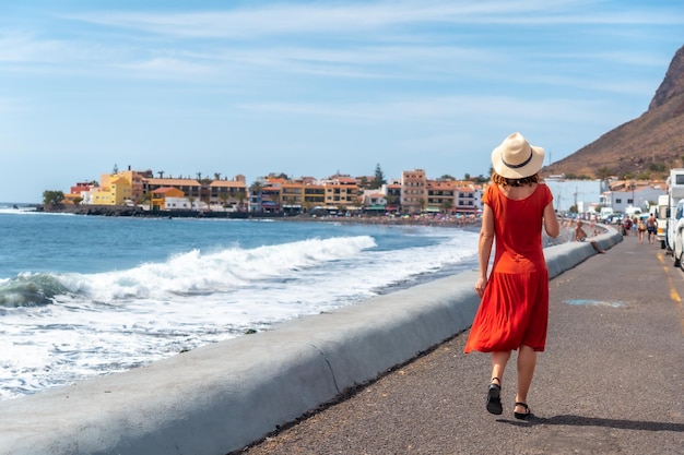 Un turista che cammina lungo la passeggiata sulla spiaggia di Valle Gran Rey a La Gomera Isole Canarie